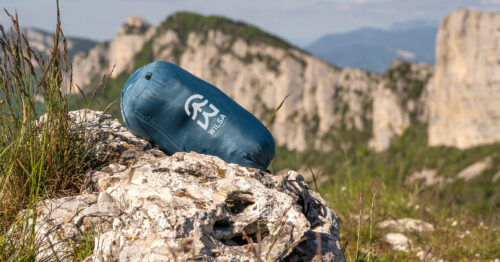sac de couchage duvet wilsa bleu dans un décor montagne